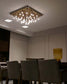 Lámpara de techo moderna colgante dorada encendida en comedor elegante, iluminación decorativa.