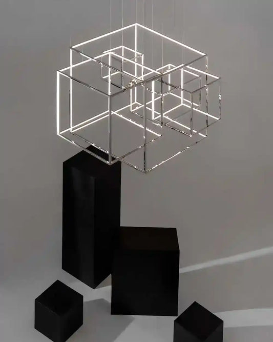 Lámpara colgante moderna de cubos geométricos con luz LED, sobre fondo minimalista gris.