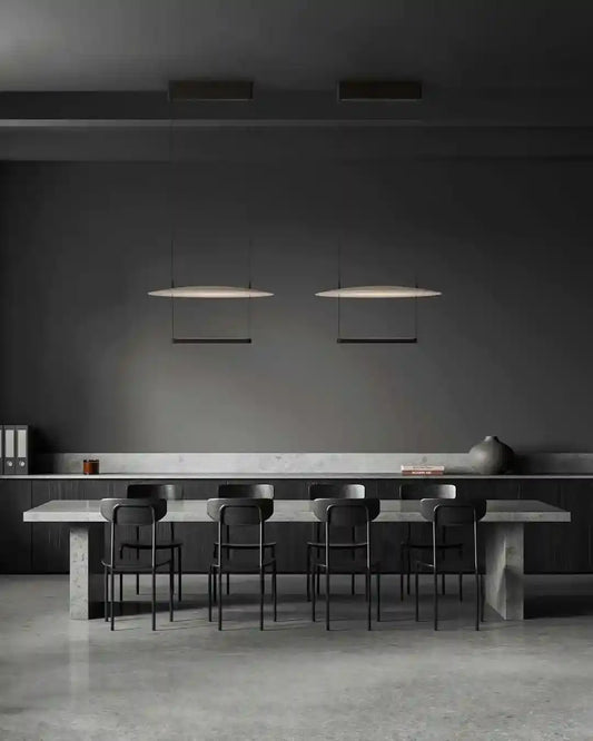 Comedor moderno con mesa de concreto, sillas negras y lámparas colgantes, boutique Birot MX.