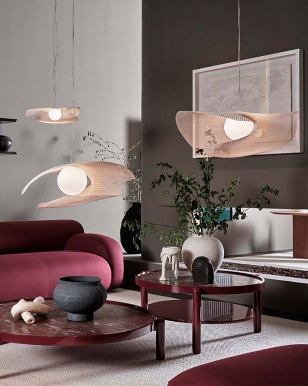 Sala moderna con lámparas colgantes de diseño, muebles burdeos y decoración elegante de Birot MX.