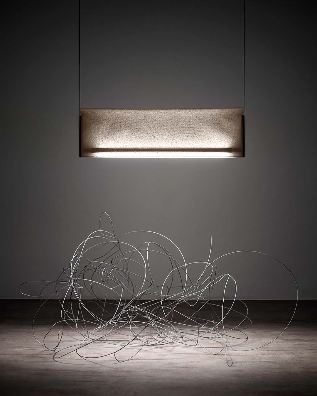 Lámpara colgante moderna iluminando escultura de alambre en ambiente minimalista, Birot MX