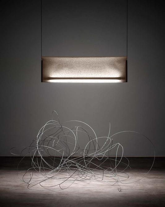 Lámpara colgante moderna iluminando escultura de alambre en ambiente minimalista, Birot MX