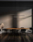 Lámpara colgante moderna sobre mesa de madera y sillas negras en comedor minimalista