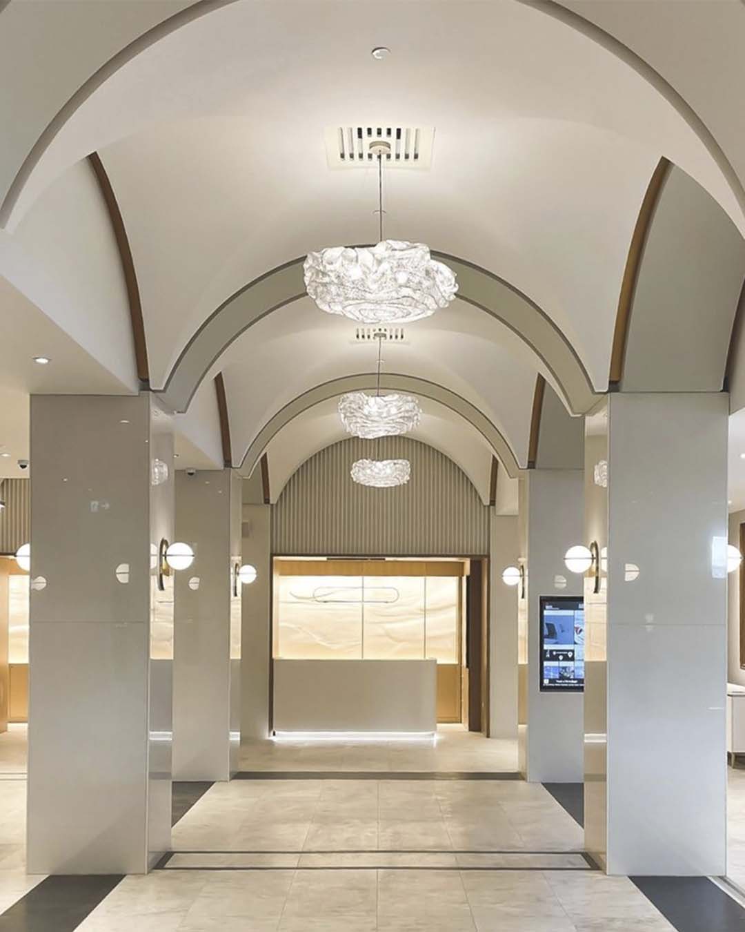 Lobby moderno con techos abovedados y lámparas decorativas, boutique de iluminación Birot MX