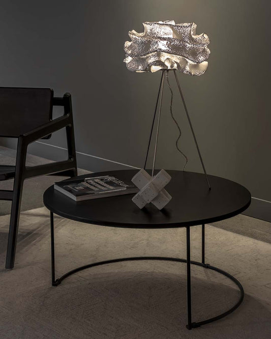 Lámpara de mesa Nevo de a-emotional light en malla de acero sobre mesa de centro.