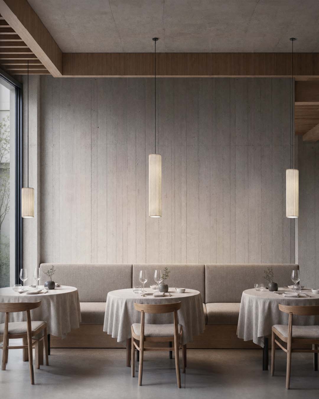 Lámpara colgante minimalista Nua en malla de acero sobre mesa de restaurante con iluminación cálida.