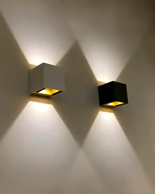 Apliques de pared modernos blanco y negro iluminando en pared, boutique de iluminación Birot MX