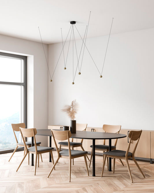 Lámpara de techo moderna con esferas doradas en comedor minimalista de madera clara.