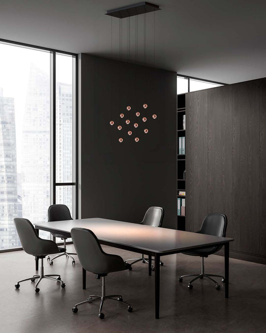 Oficina moderna con lámpara colgante decorativa y mesa de juntas con sillas negras.