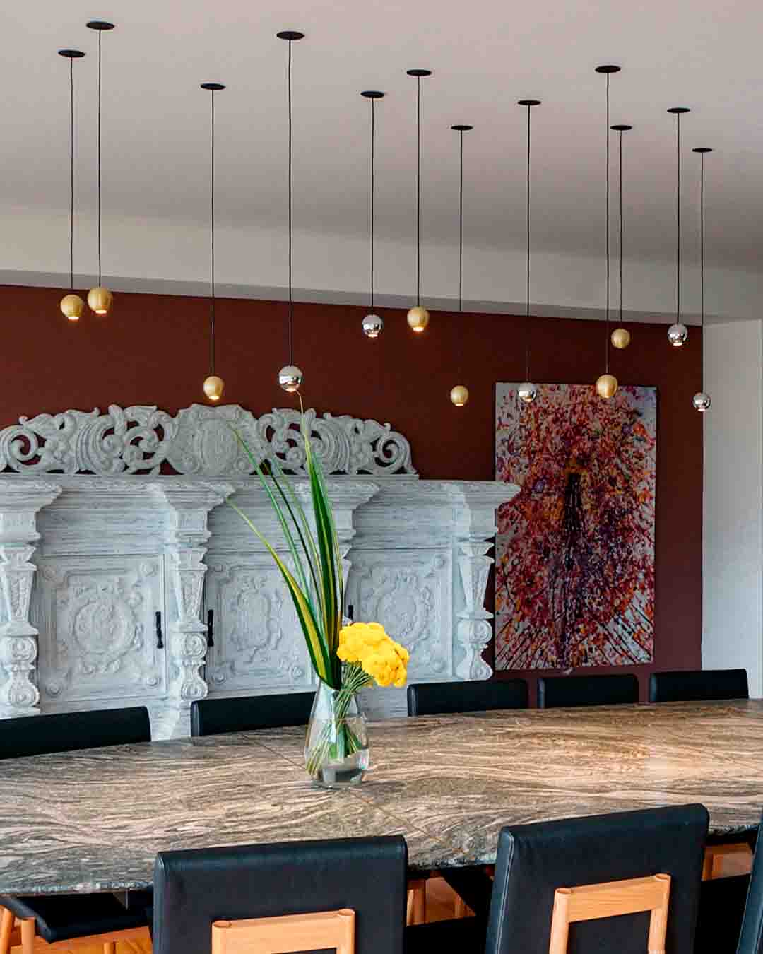 Lámparas colgantes modernas doradas y plateadas sobre mesa de comedor elegante