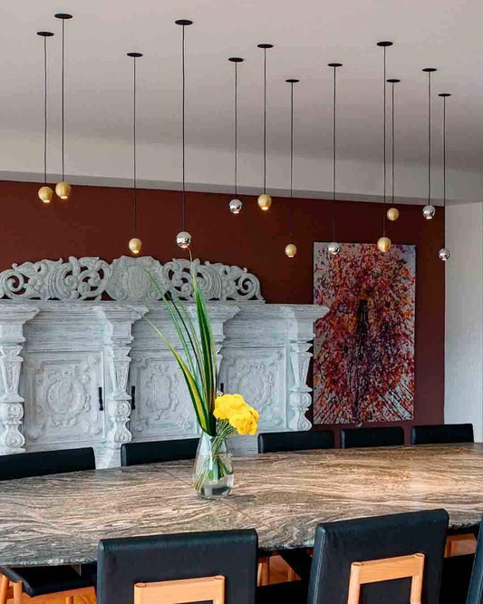 Lámparas colgantes modernas sobre mesa de comedor, decoración elegante Birot MX iluminación.