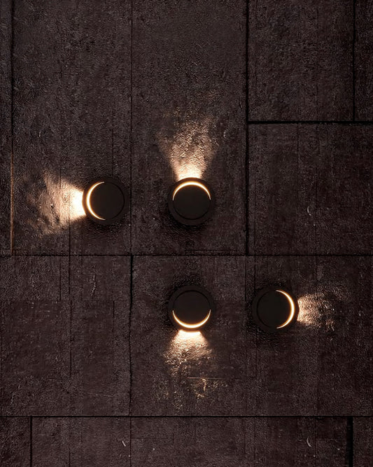 Lámparas de pared LED modernas redondas en muro oscuro, iluminación decorativa.