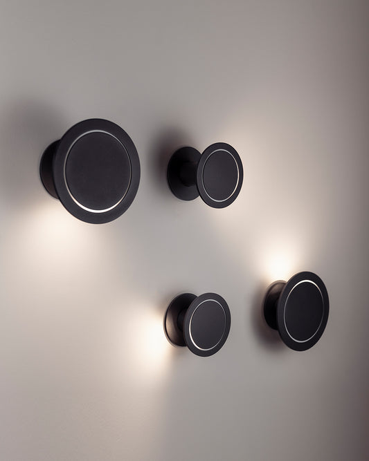 Apliques de pared modernos circulares negros con luz LED en fondo gris, iluminación decorativa.