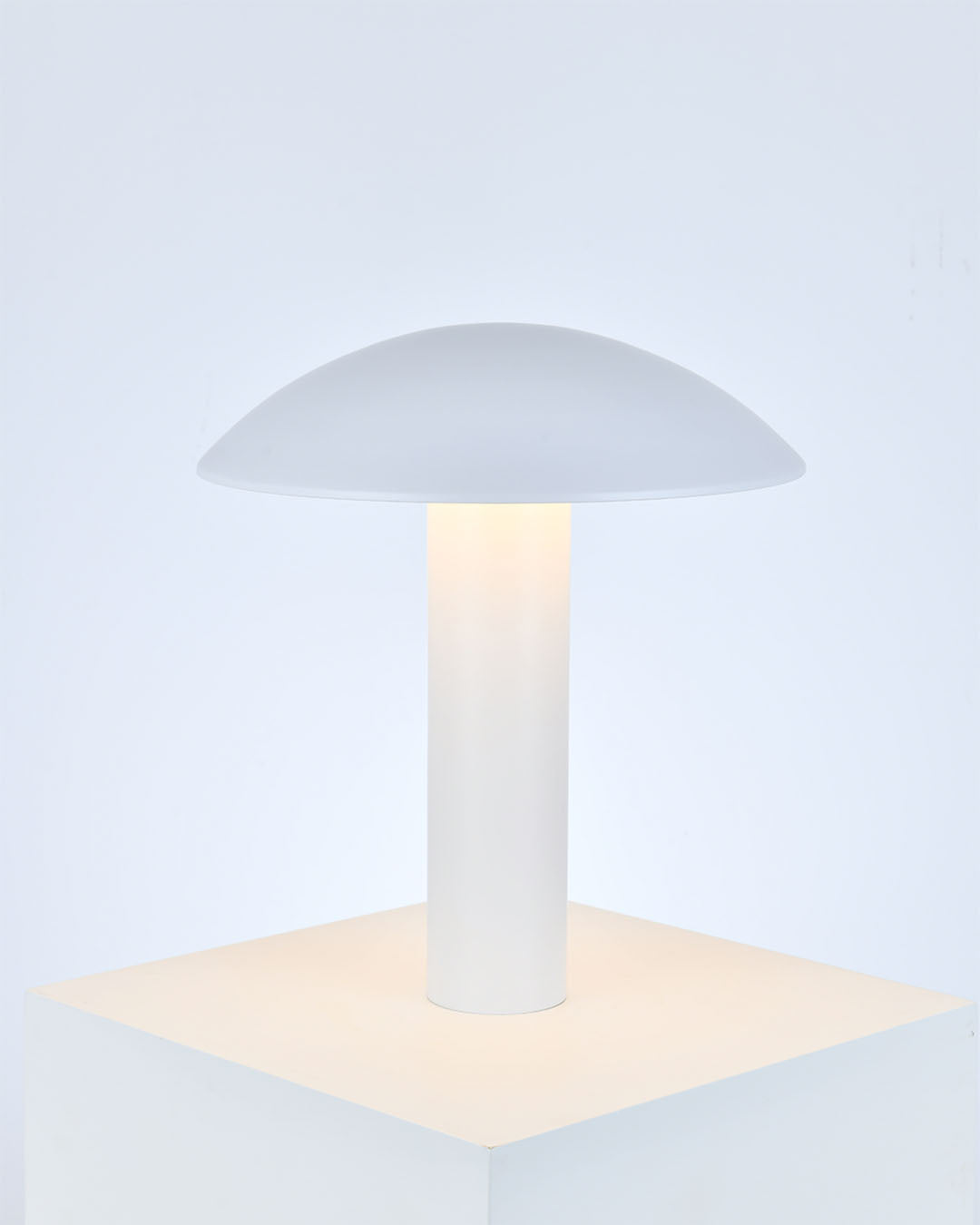 Lámpara de mesa blanca de diseño minimalista, iluminación ambiente suave.
