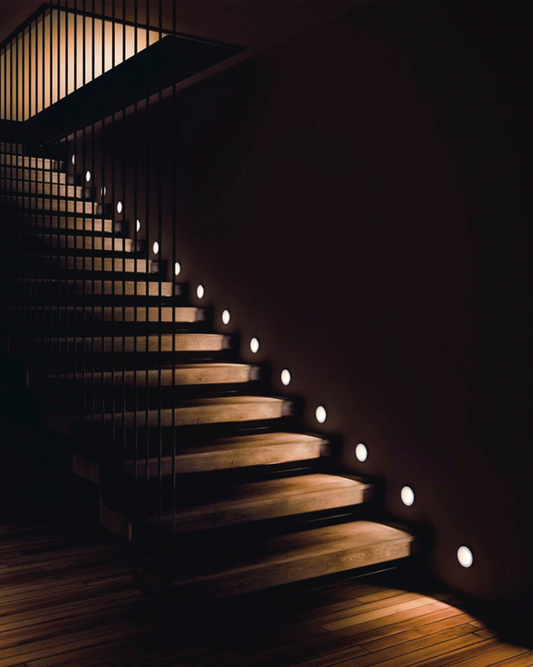 Escalera moderna con iluminación LED empotrada en la pared y ambiente minimalista.