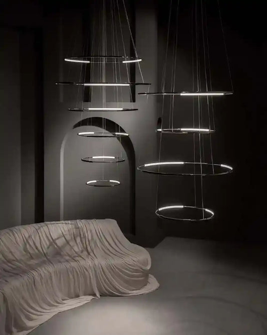 Lámparas colgantes modernas circulares sobre sofá cubierto en sala minimalista oscura