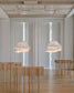Lámparas colgantes de diseño moderno en sala minimalista con muebles de madera clara.