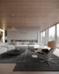 Sala moderna con sofá blanco, lámparas colgantes decorativas y silla de diseño junto a ventanales.