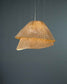 Lámpara colgante Tempo Vivace en malla de acero color beige encendida. 