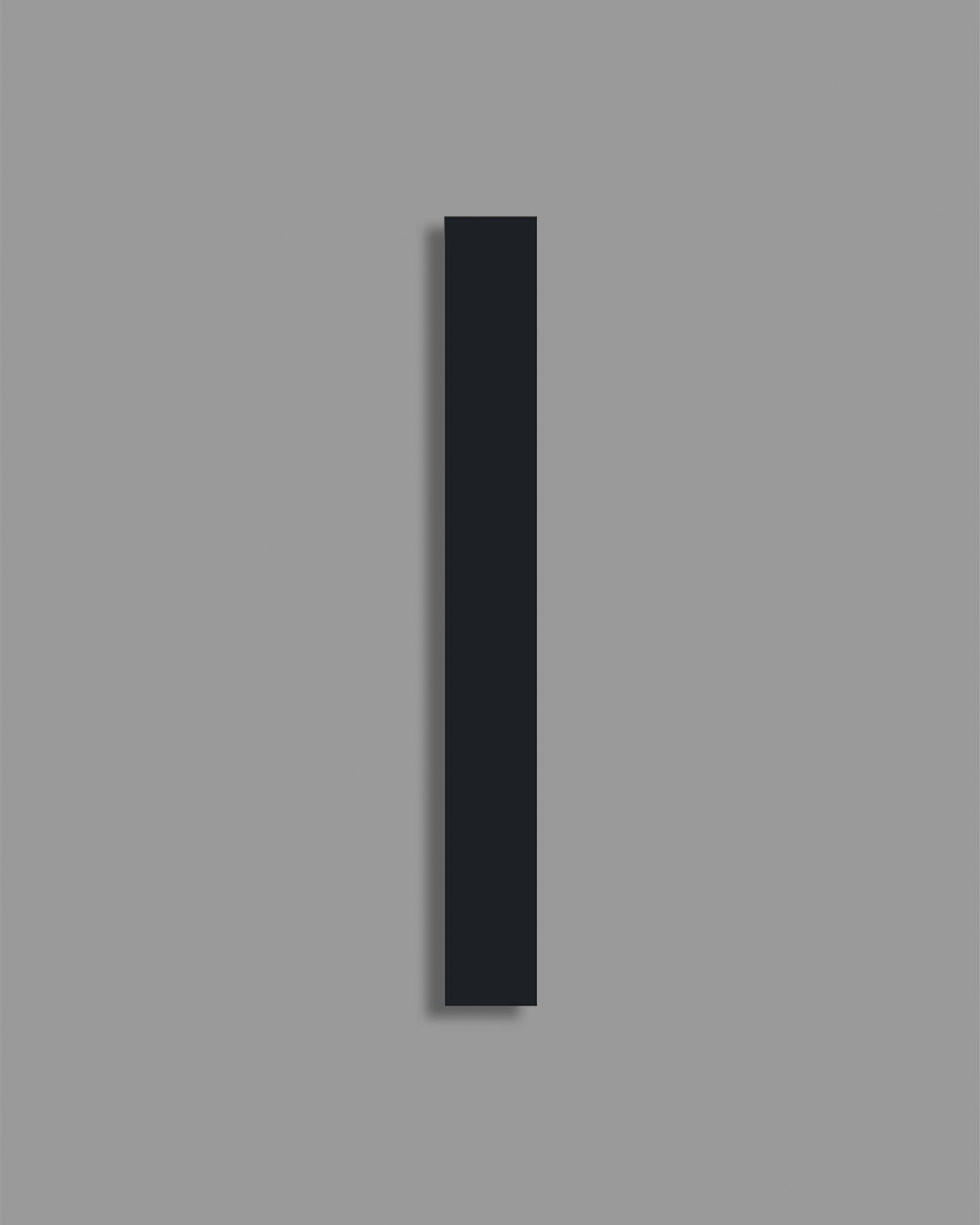 Aplique de pared rectangular negro, diseño minimalista sobre fondo gris.