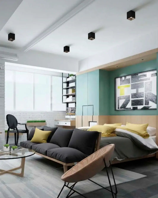 Sala moderna con focos de techo negros, sofá gris y decoración minimalista luminosa