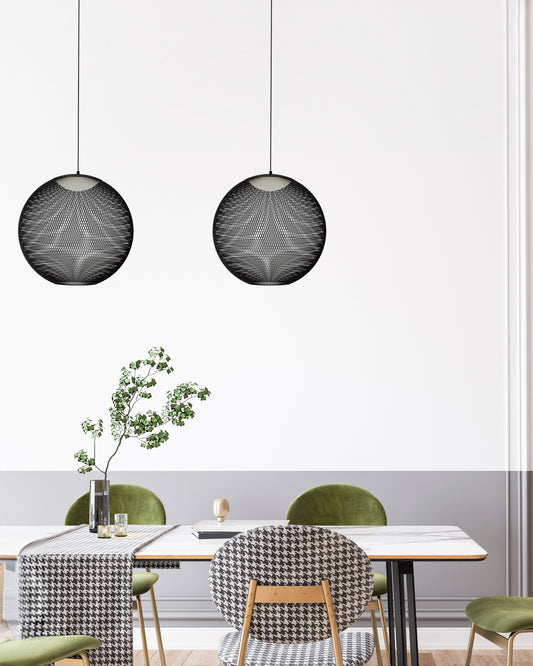 Lámparas colgantes negras modernas sobre mesa comedor con sillas verdes y decoración elegante