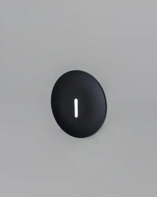 Lámpara de pared LED negra redonda moderna sobre fondo gris para iluminación interior
