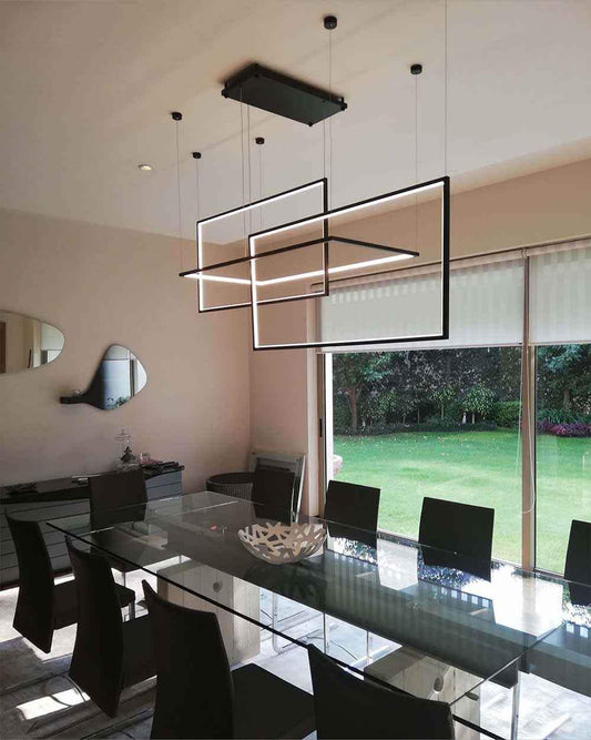 Lámpara moderna rectangular de Birot MX en comedor elegante con mesa de cristal y vista al jardín
