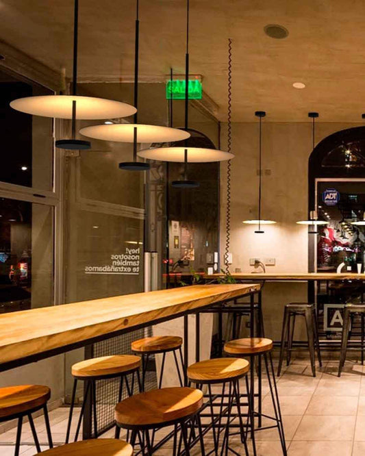 Lámparas colgantes modernas sobre barra de madera en cafetería, iluminación de diseño Birot MX