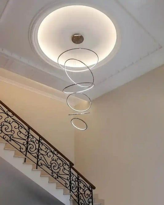 Lámpara colgante moderna de aros LED en escalera interior, iluminación boutique Birot MX