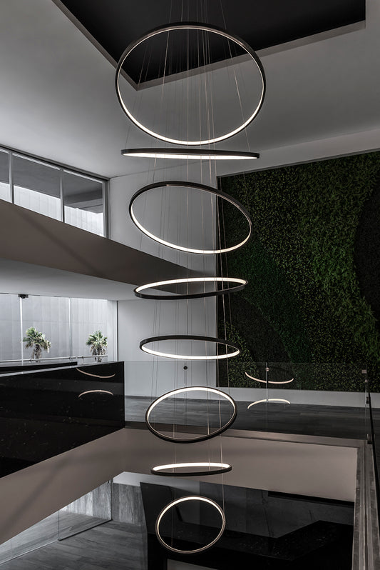 Lámpara colgante moderna de aros LED en escalera de interior elegante