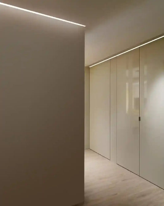Pasillo minimalista con iluminación lineal empotrada en techo, boutique de iluminación Birot MX