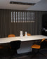 Lámpara colgante moderna sobre mesa blanca con sillas mostaza y decoración minimalista