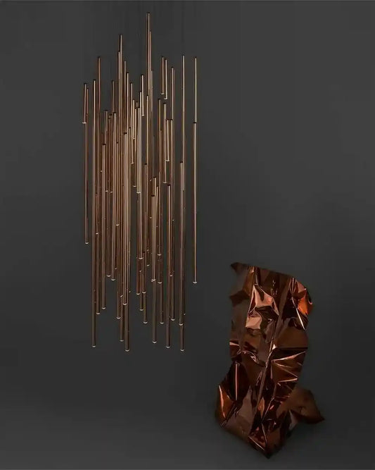 Lámpara colgante moderna de tubos dorados sobre fondo oscuro, boutique de iluminación Birot MX