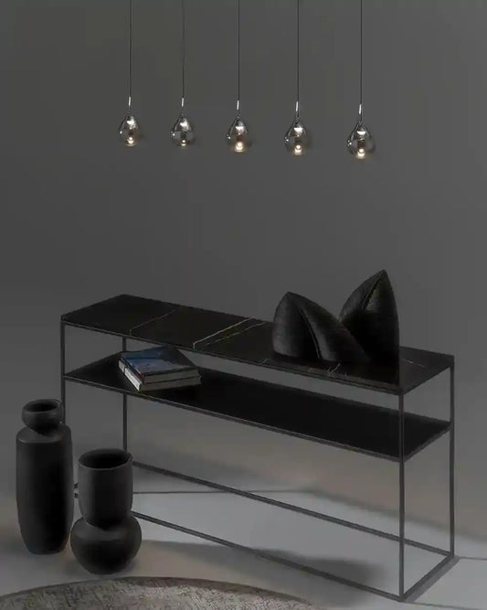 Lámparas colgantes modernas sobre consola negra y decoración minimalista, Birot MX iluminación.