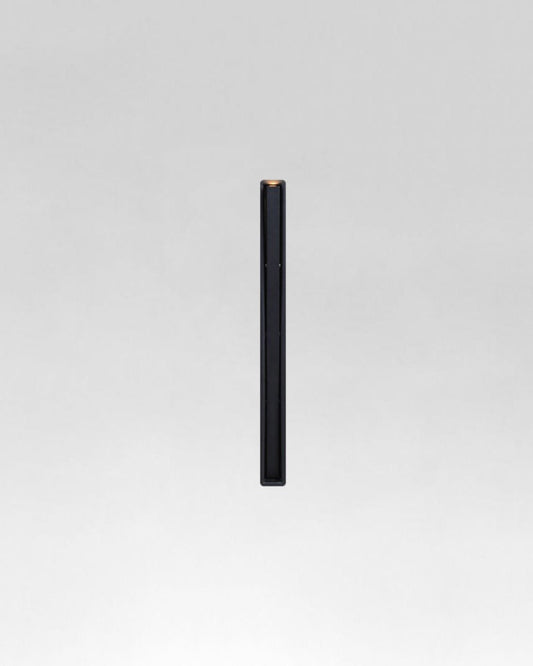 Lámpara de exterior minimalista negra tipo poste sobre fondo gris