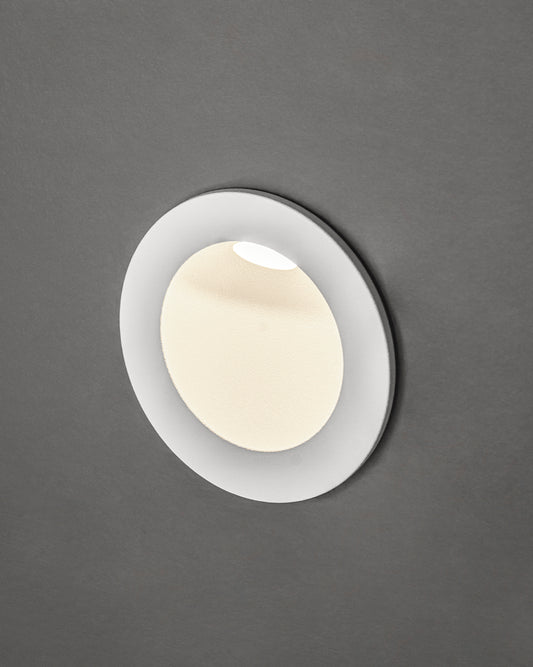 Lámpara empotrable de techo blanca, diseño minimalista, encendida sobre fondo gris.