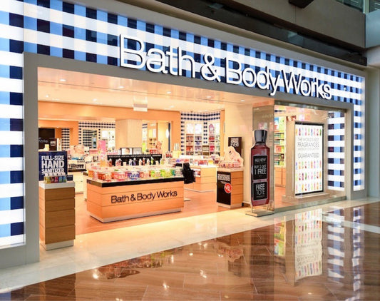 Fachada de tienda Bath & Body Works en centro comercial con productos de cuidado personal visibles.