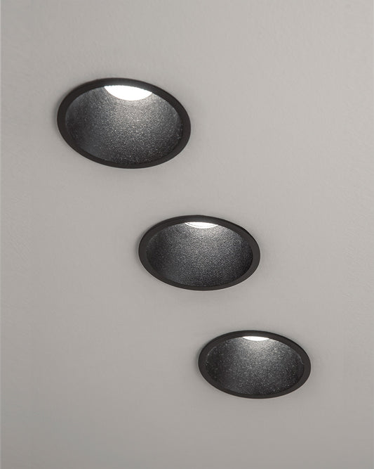 Tres lámparas de techo empotradas de diseño moderno en acabado negro sobre fondo blanco.