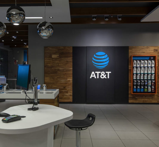 Tienda de tecnología moderna con logo de AT&T, mostrador y luces colgantes de diseño.