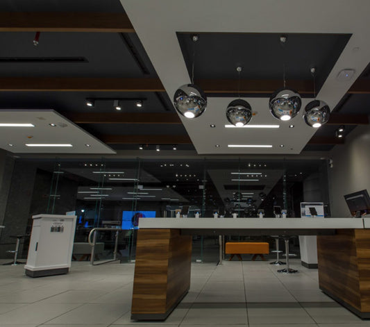 Lámparas colgantes esféricas cromadas sobre mesa moderna en tienda de iluminación