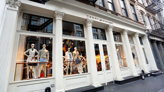 Fachada de tienda de ropa con maniquíes en escaparate y columnas clásicas blancas