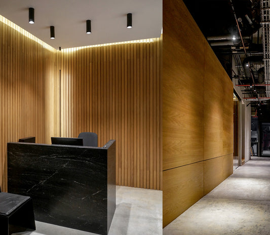 Recepción moderna con iluminación de techo, paredes de madera y mostrador negro elegante.
